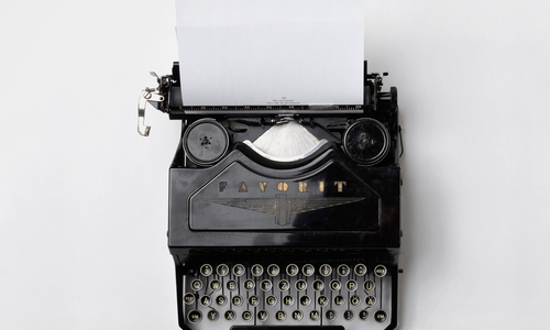 Schwarze Schreibmaschine auf weißem Hintergrund.