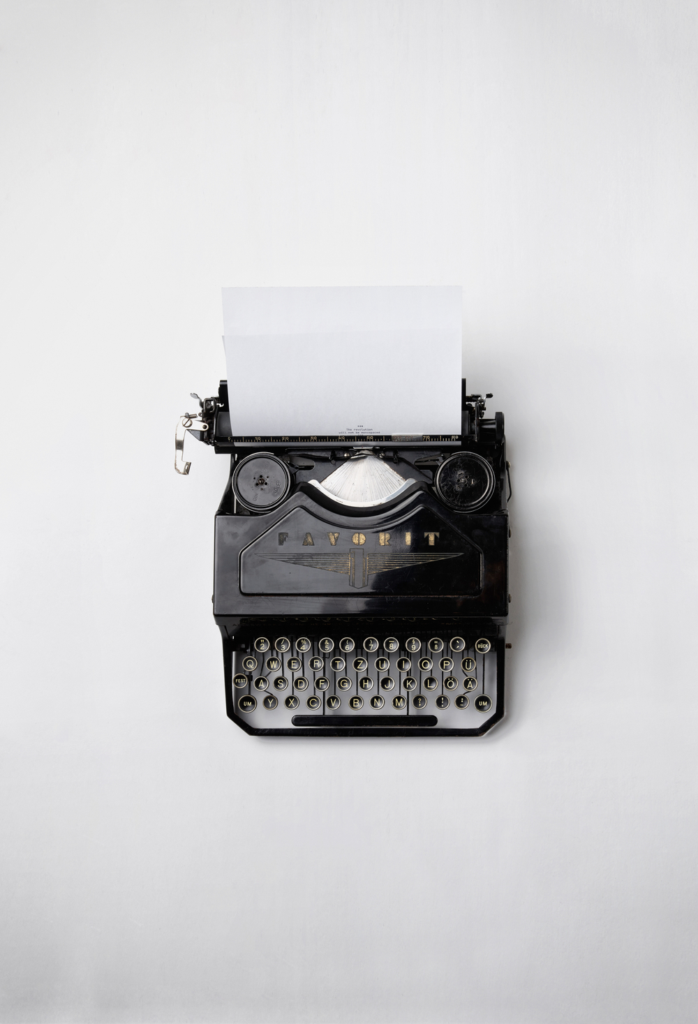 Schwarze Schreibmaschine auf weißem Hintergrund.