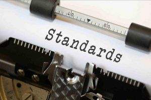 Nahaufnahme einer Schreibmaschine mit eingespanntem Papier und darauf abgetippter Aufschrift "Standards"